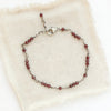 The wrapped garnet bracelet styled on tan linen