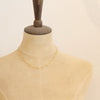 A mannequin wearing the gold paperclip necklace