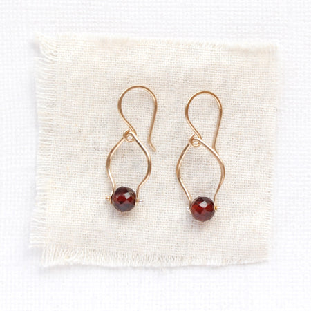 The garnet delhi earrings styled on tan linen