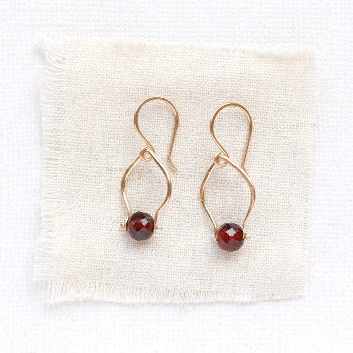 The garnet delhi earrings styled on tan linen
