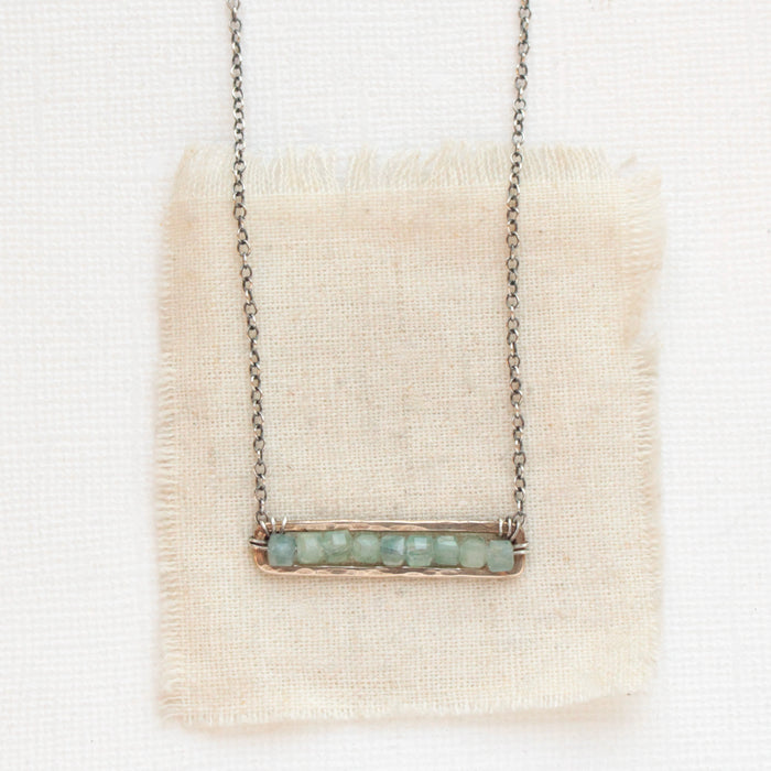 The green apatite beaded bronze bar necklace styled on tan linen