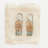 The bronze wanderer arch green apatite earrings styled on tan linen