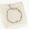 The wrapped green kyanite bracelet styled on tan linen