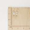 The silver herkimer diamond la cloche earrings on a wooden ruler for size reference