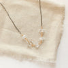 The mixed metal herkimer diamone necklace styled on tan linen