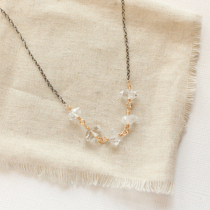 The mixed metal herkimer diamone necklace styled on tan linen