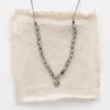 The knotted zircon roma necklace styled on tan linen