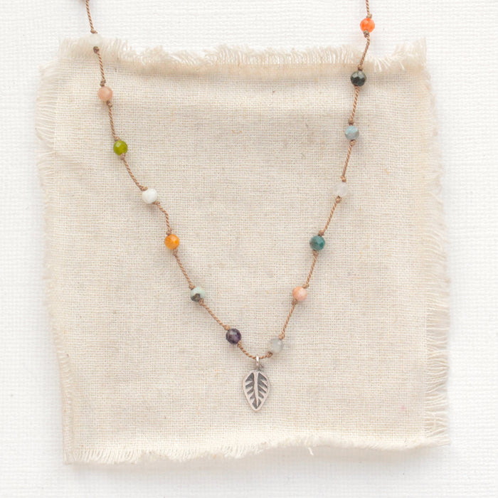 The knotted kaleidoscope necklace styled on tan silk