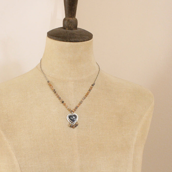 A mannequin wearing the knotted moonstone heart necklace