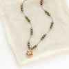 The knotted pyrite and bronze mini cactus flower is styled on tan linen