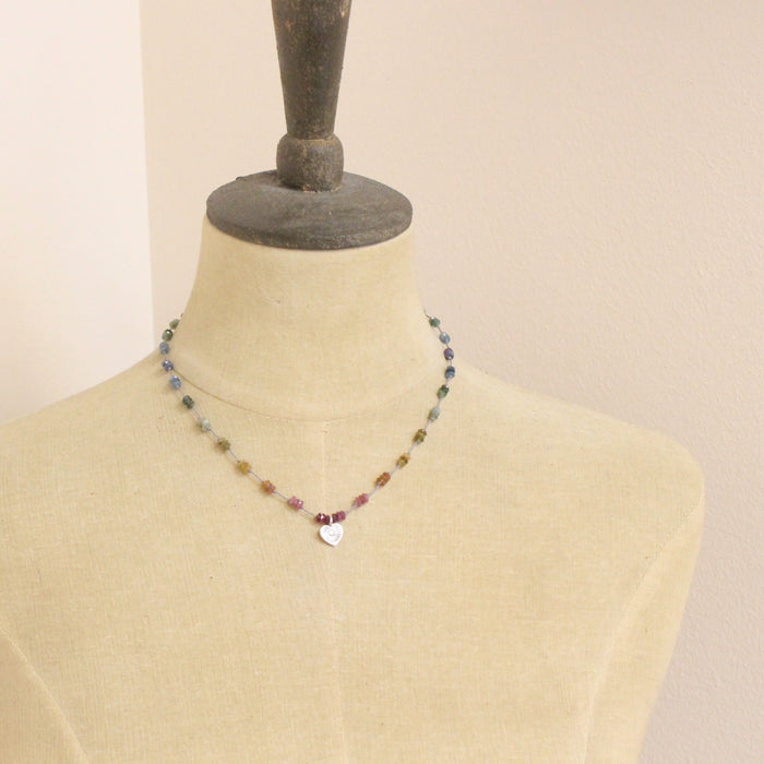 A mannequin wearing the knotted tourmaline heart necklace