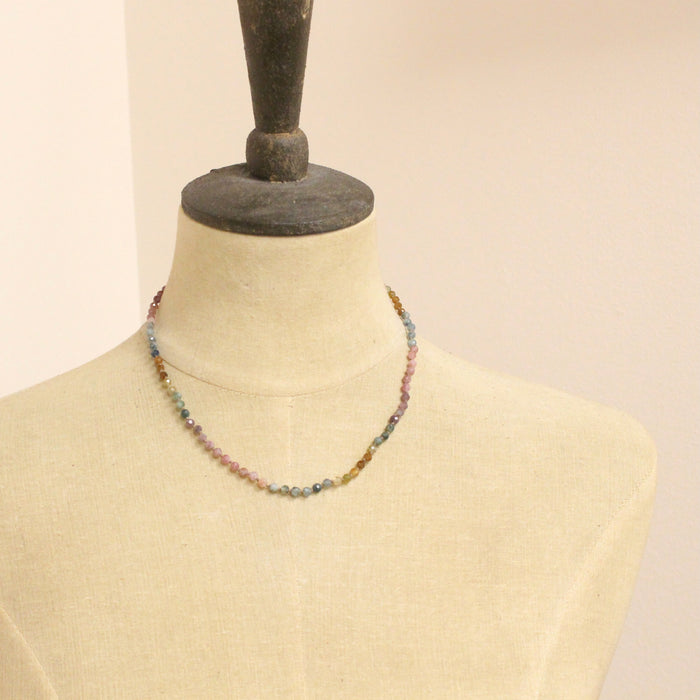 A mannequin wearing the knotted rainbow tourmaline necklace