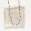 The knotted aquamarine necklace styled on tan linen