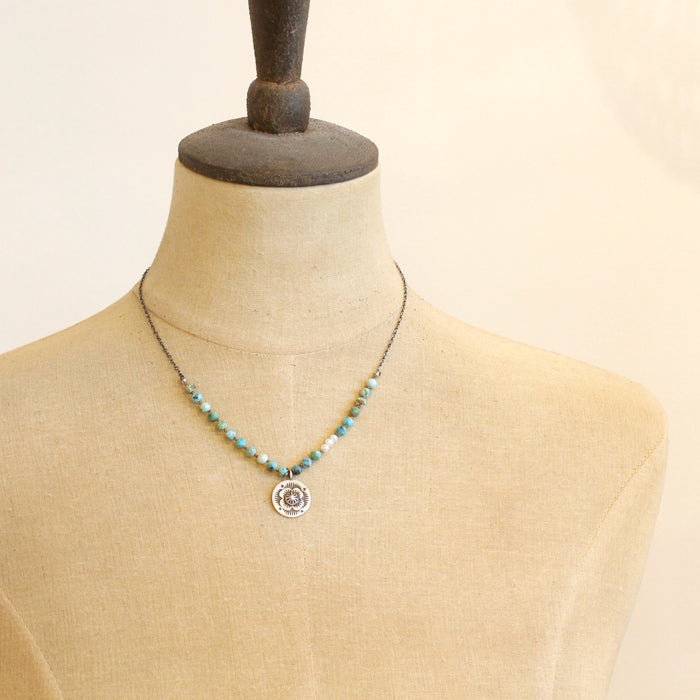 A mannequin wearing the knotted seaside columbine medallion necklace