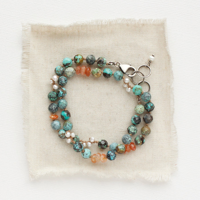 The knotted sunset bracelet styled on tan linen