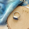 The kyanite ring styled on wood to show the silver band