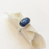 The kyanite ring styled on rolled tan linen