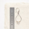 A labradorite wrapped teardrop hoop earring next to a ruler for size reference