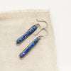 The lapis beaded bar earrings styled on tan linen
