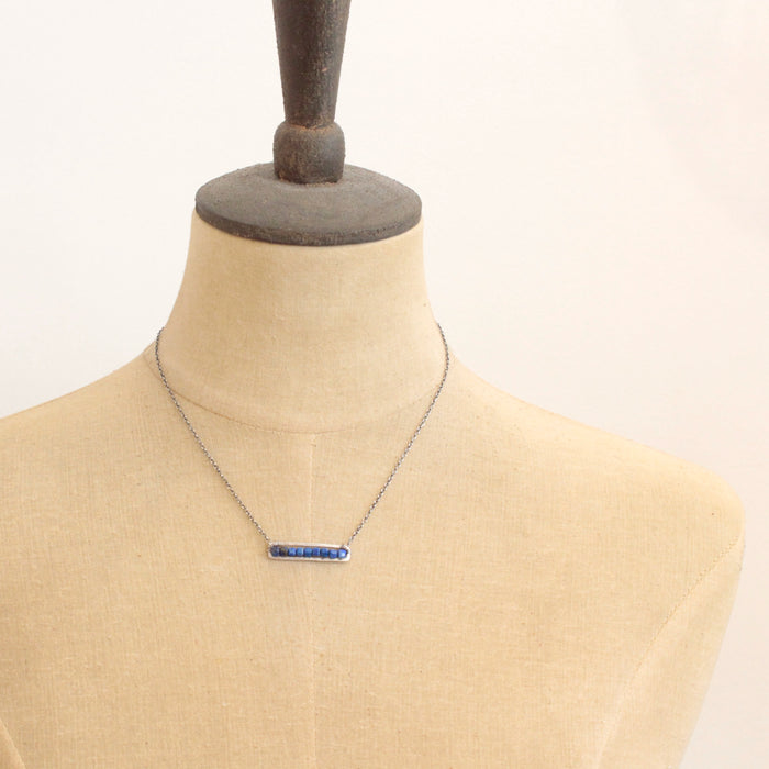 A mannequin wearing the lapis beaded bar necklace