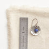 A lapis cupped jolie earring next to a ruler for size reference