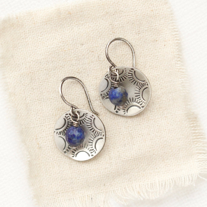 The lapis cupped jolie earrings styled on tan linen