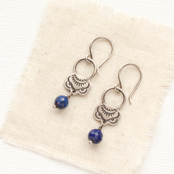 The lapis jolie earrings styled on tan linen