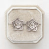 The layered cactus flower post earrings styled on a white velvet box