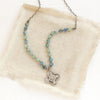 The layered talara knotted kyanite necklace styled on tan linen