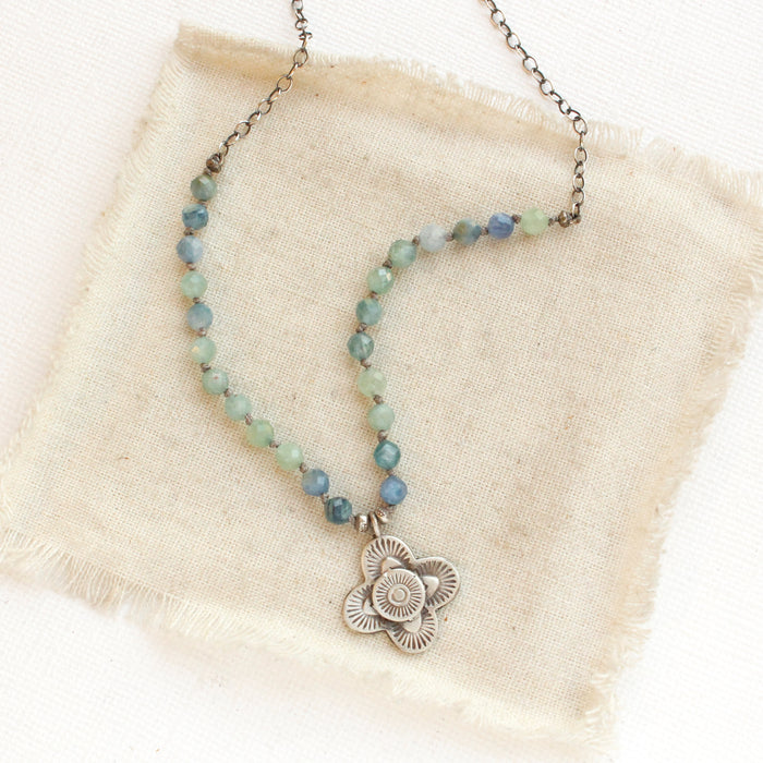 The layered talara knotted kyanite necklace styled on tan linen