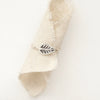 The leaf stacking ring styled on a piece of rolled linen