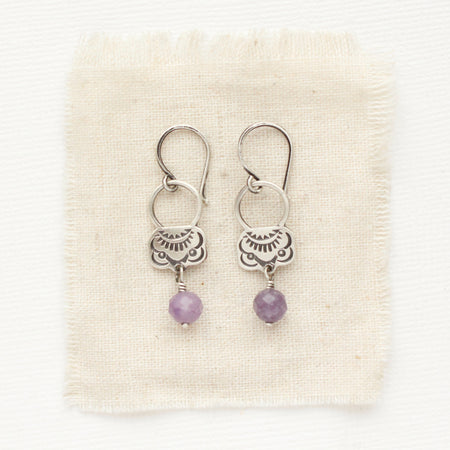 The lepidolite jolie earrings styled on tan linen