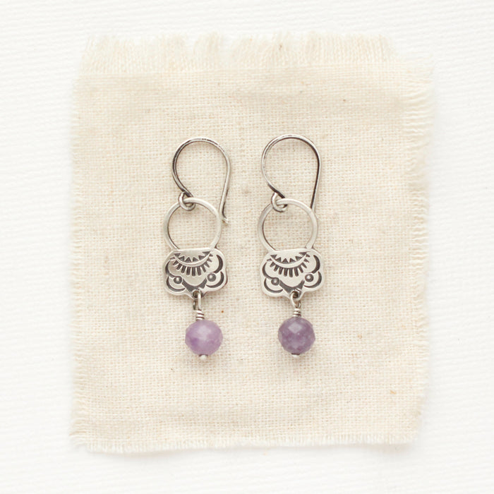 The lepidolite jolie earrings styled on tan linen