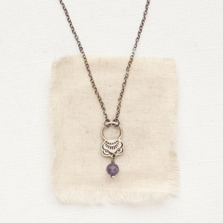 The lepidolite jolie necklace styled on tan linen