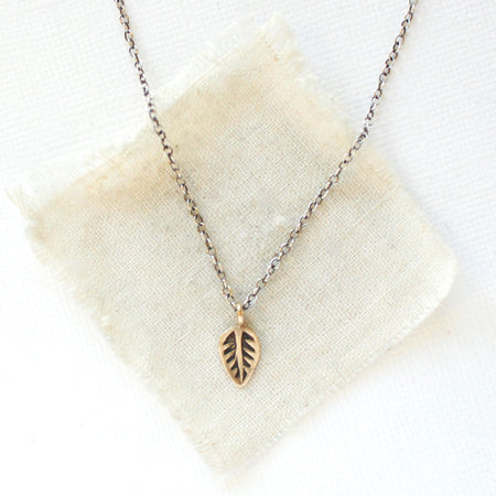 The bronze leaf necklace styled on tan linen
