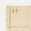 The little aquamarine gold hoop earring styled on a wooden ruler