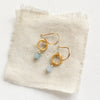 The little aquamarine gold hoop earrings styled on tan linen