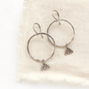 The sun rise hoop earrings styled on tan linen