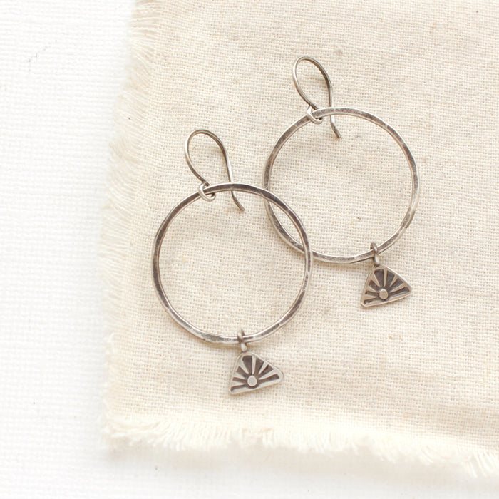 The sun rise hoop earrings styled on tan linen