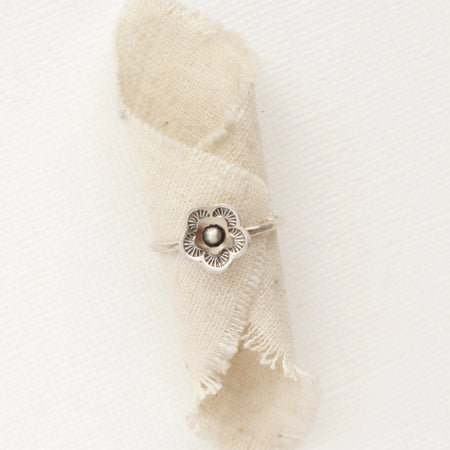 The mini cactus flower stacking ring styled on a piece of rolled linen