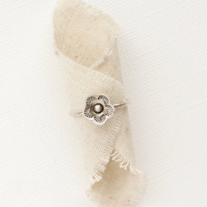 The mini cactus flower stacking ring styled on a piece of rolled linen