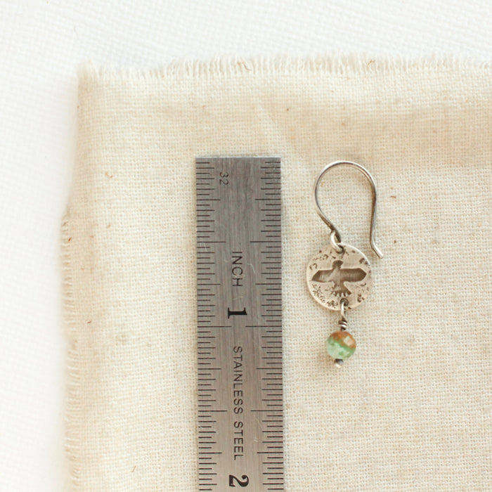 A mini soar turquoise earring next to a ruler for size reference