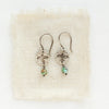The mini soar turquoise dangle earrings styled on tan linen