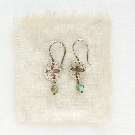The mini soar turquoise dangle earrings styled on tan linen
