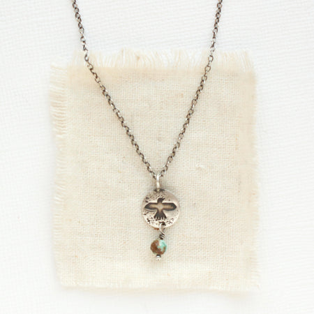 The mini soar and turquoise necklace styled on tan linen
