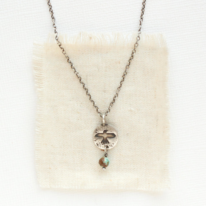 The mini soar and turquoise necklace styled on tan linen
