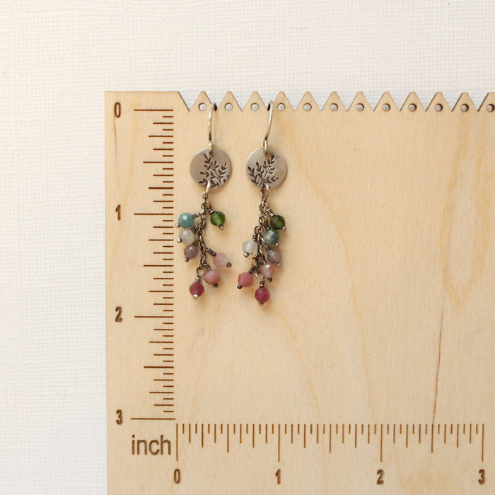 The mini sprout rainbow tourmaline earrings on a ruler for size reference