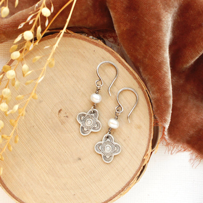 The mini talara pearl earrings styled on wood with orange velvet and dried grass