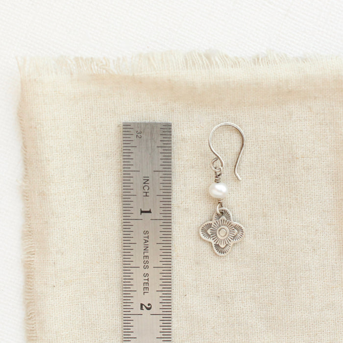A mini talara pearl earring next to a ruler for size reference