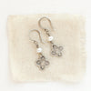 The mini talara pearl earrings styled on tan linen